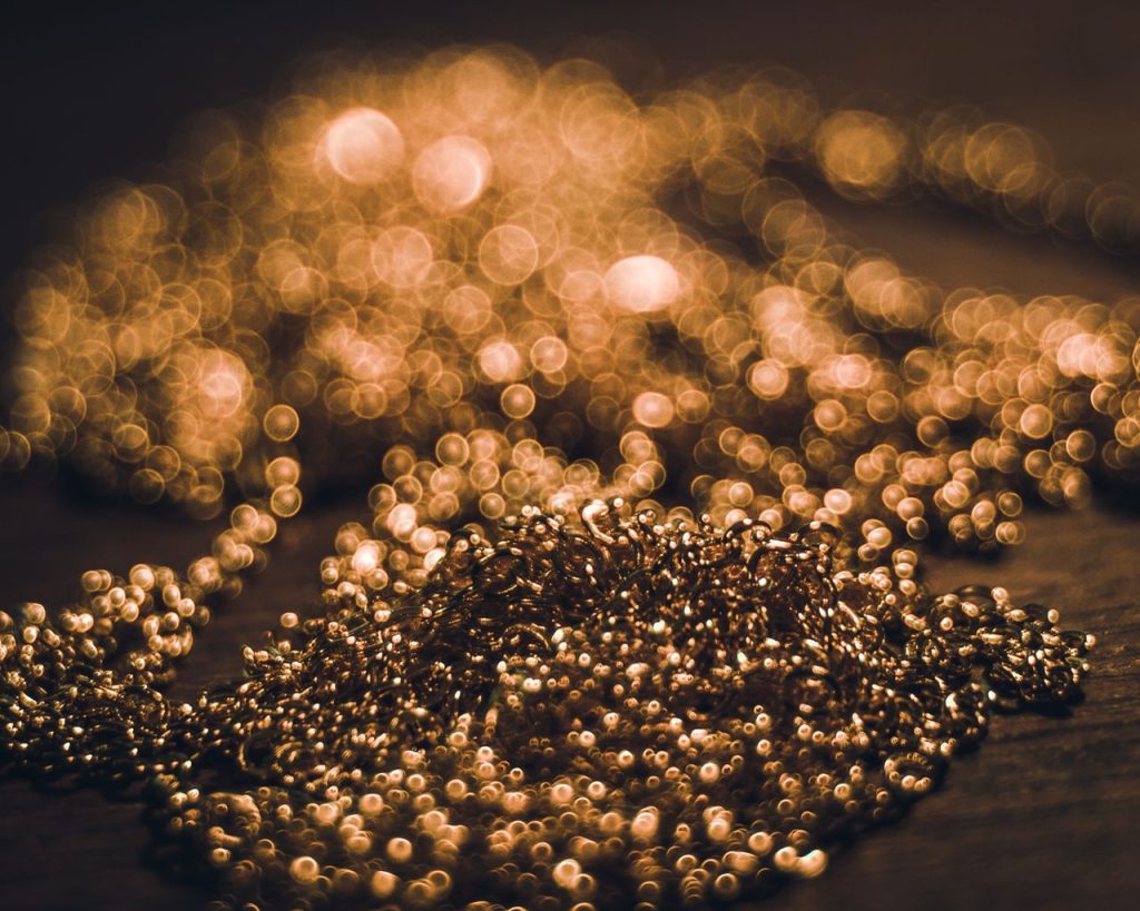 The Art of Drawing Readers In: Your attractive post title goes here Abstract close-up of golden beads with a stunning bokeh effect, showcasing shimmering lights.